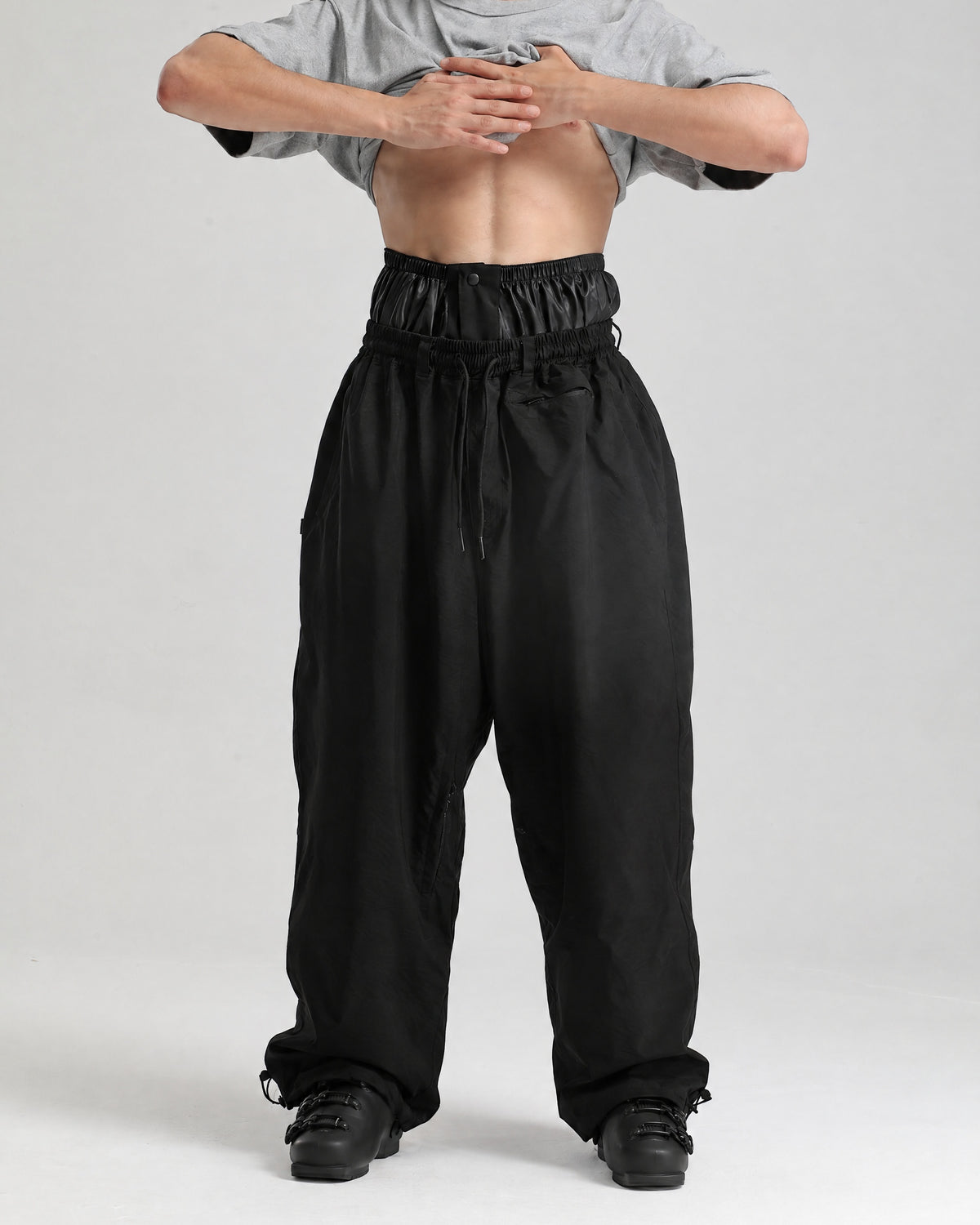 NOJU Core 2L baggy ski pants in black, front view with inner powder skirt and drawstring waist
