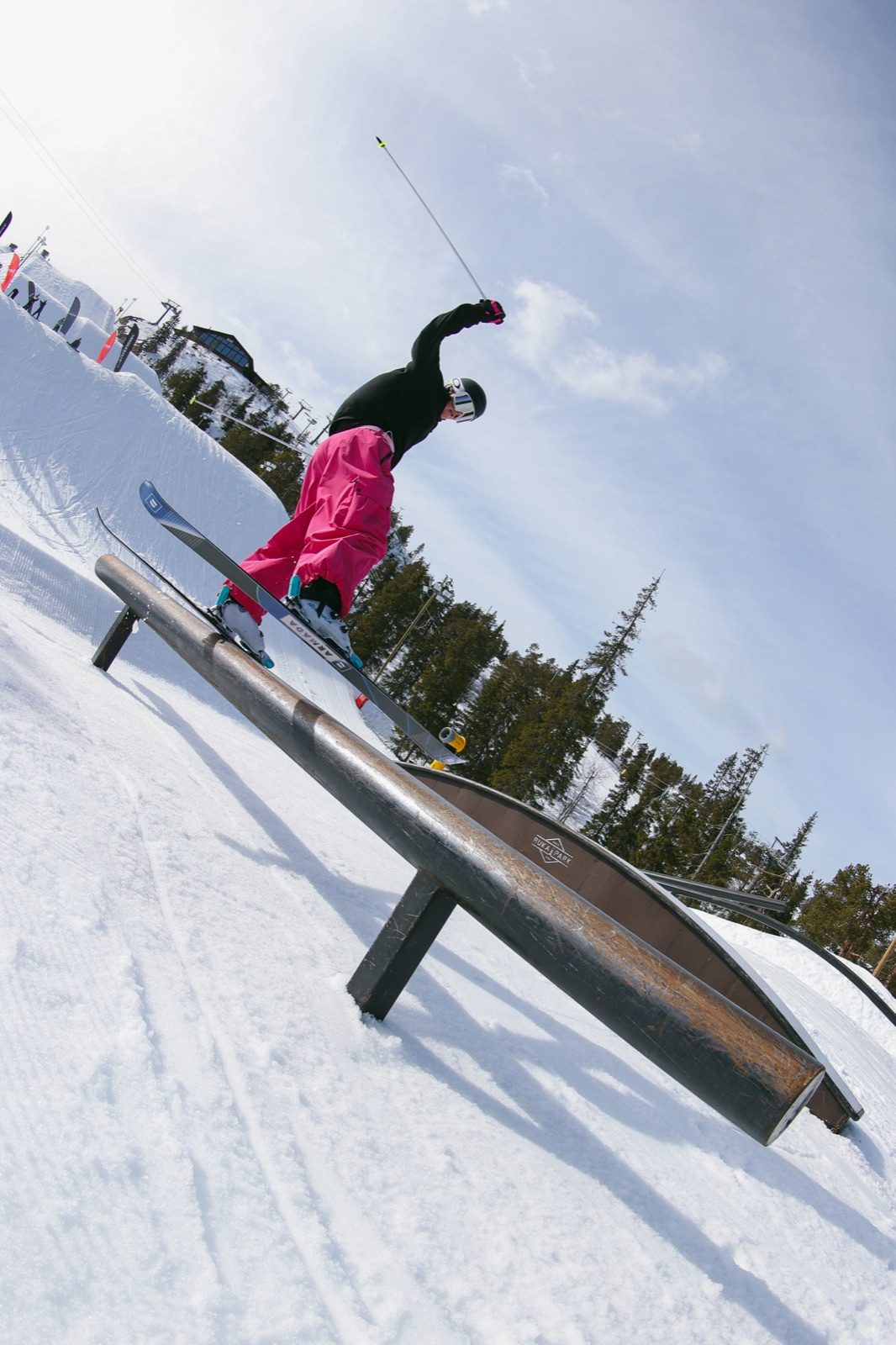 Skier grinding a rail in pink baggy pants