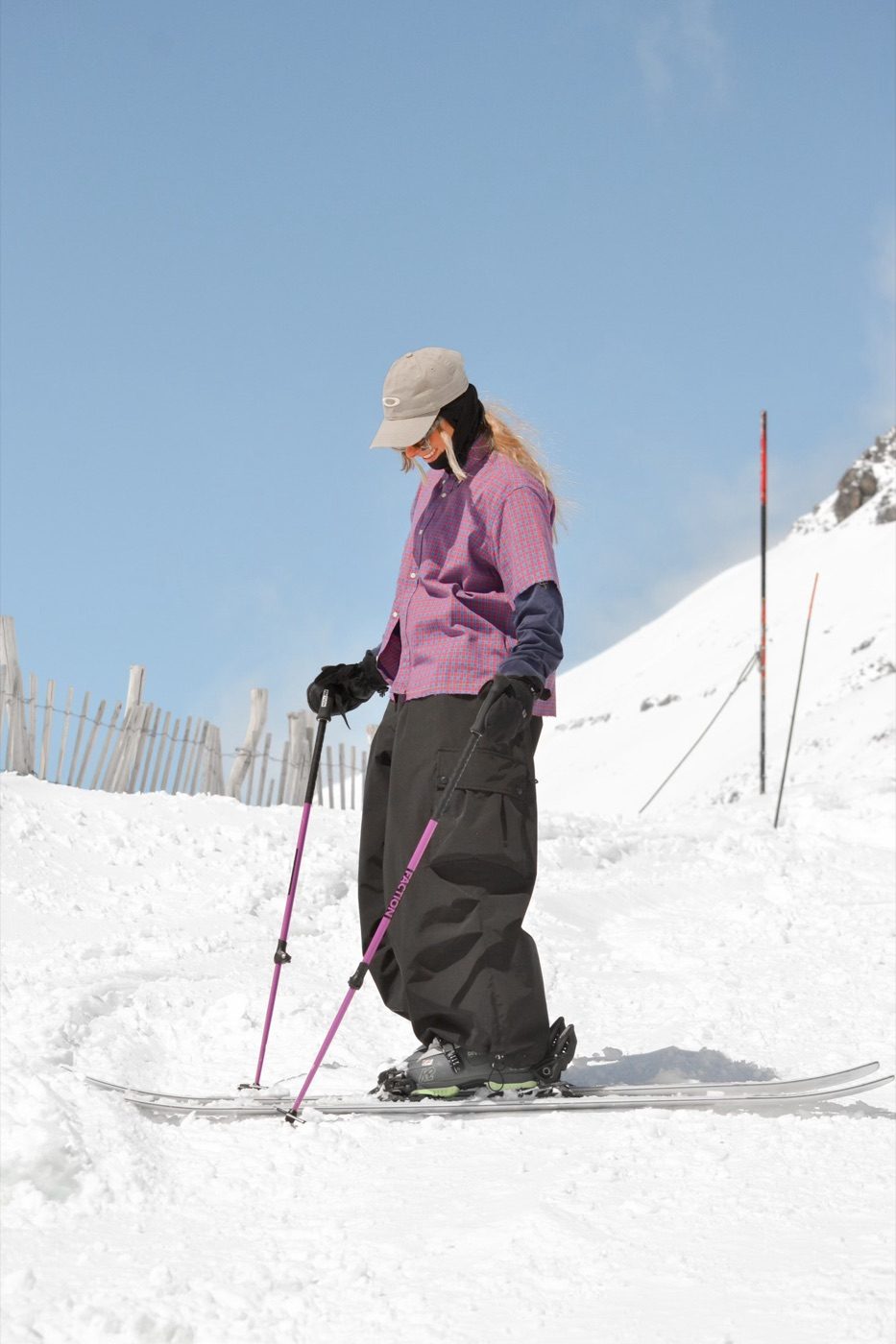 Skier in baggy black pants on sunny slope